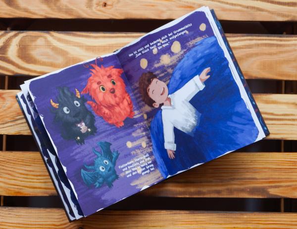 Aufgeschlagene Bilderbuchseite mit einem Kind und Monstern