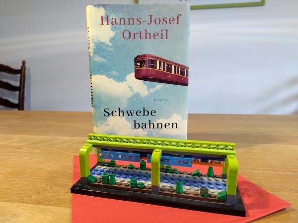 Cover des Buchs 'Schwebebahnen' mit einer Legoschwebebahn davor