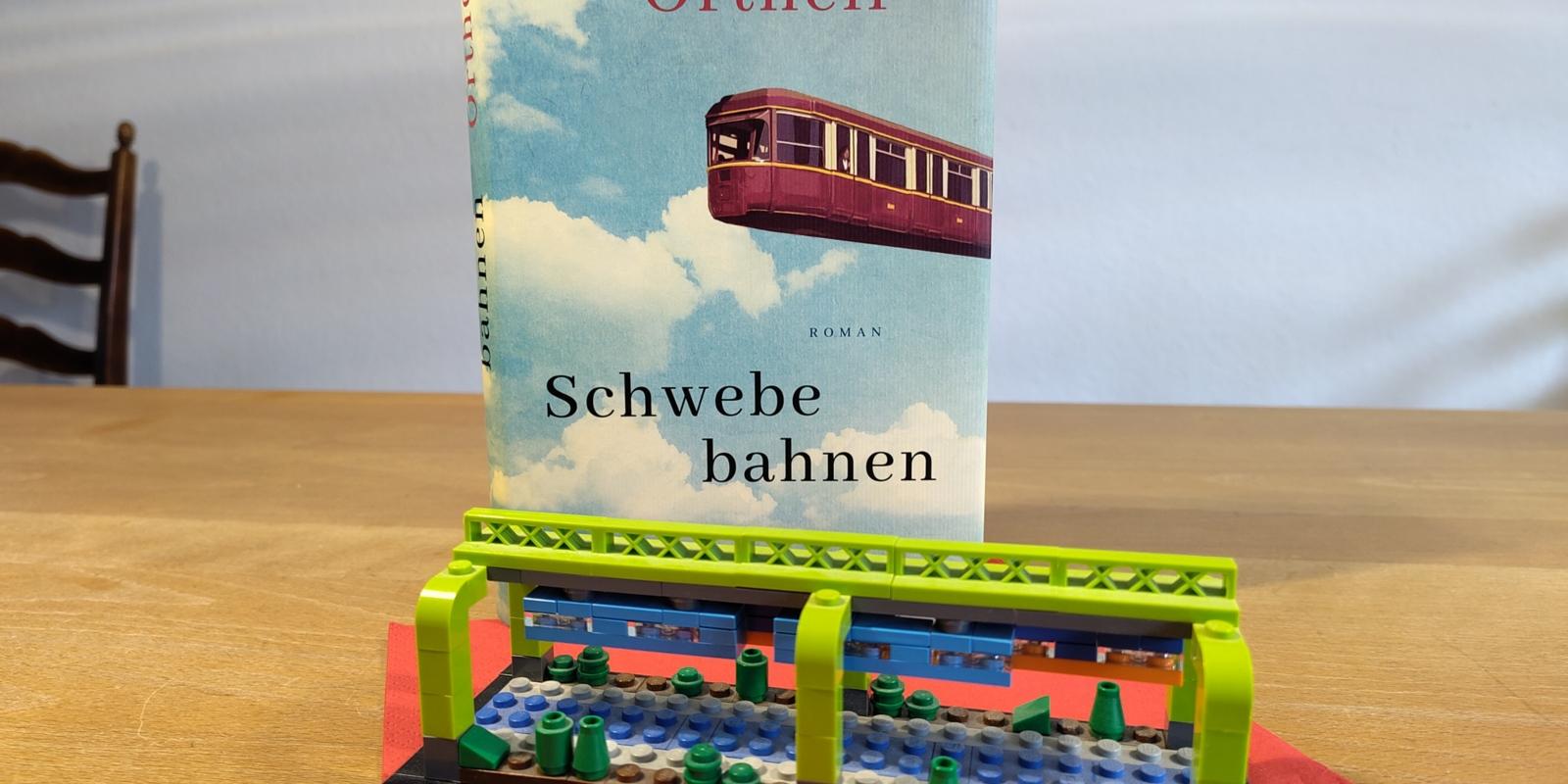 Cover des Buchs 'Schwebebahnen' mit einer Legoschwebebahn davor