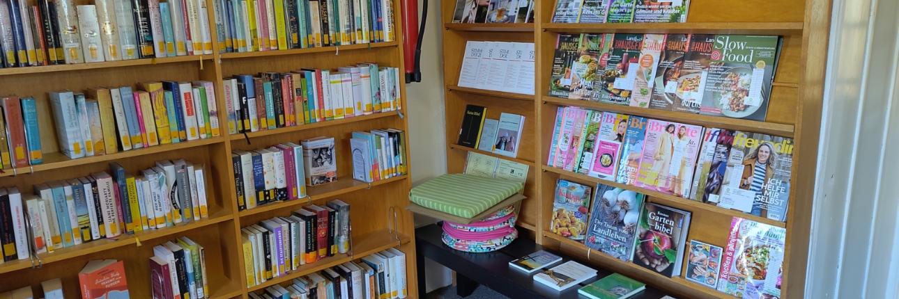 Bücherregal mit Romanen und Zeitungen