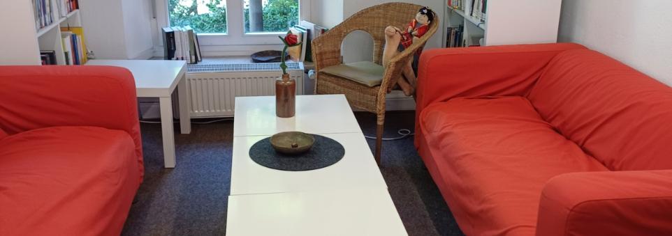 2 rote Sofas mit einem weißen Couchtisch