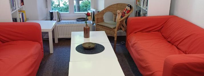 2 rote Sofas mit einem weißen Couchtisch