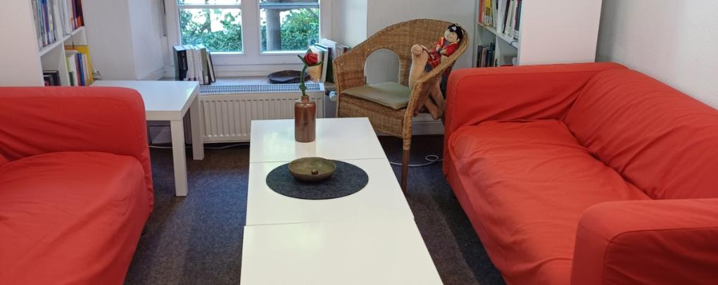 2 rote Sofas mit einem weißen Couchtisch
