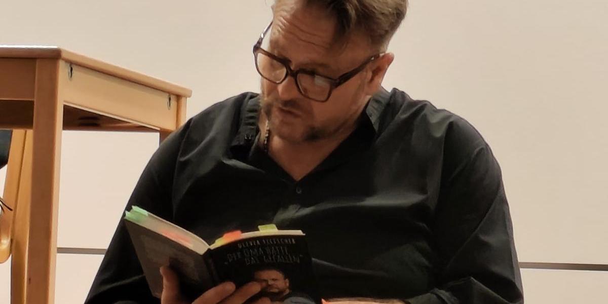 Oliver Fischer sitzend bei der Lesung